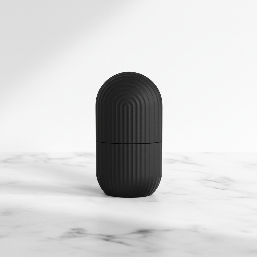 Black capsule ice roller on white marble surface
